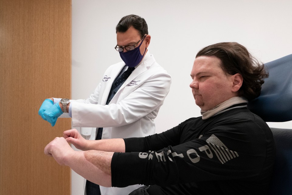 A doctor examines a patient's new hands.