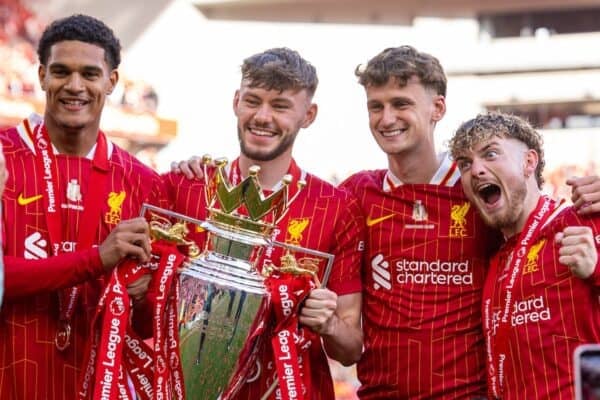 Liverpool players pose with the trophy after winning the premier league.