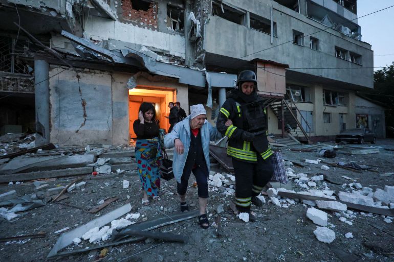 A rescuer assists a woman during an evacuation from an apartment building damaged by a Russian drone strike, amid Russia's attack on Ukraine, in Kharkiv, Ukraine June 12, 2025. REUTERS/Vyacheslav Madiyevskyy TPX IMAGES OF THE DAY