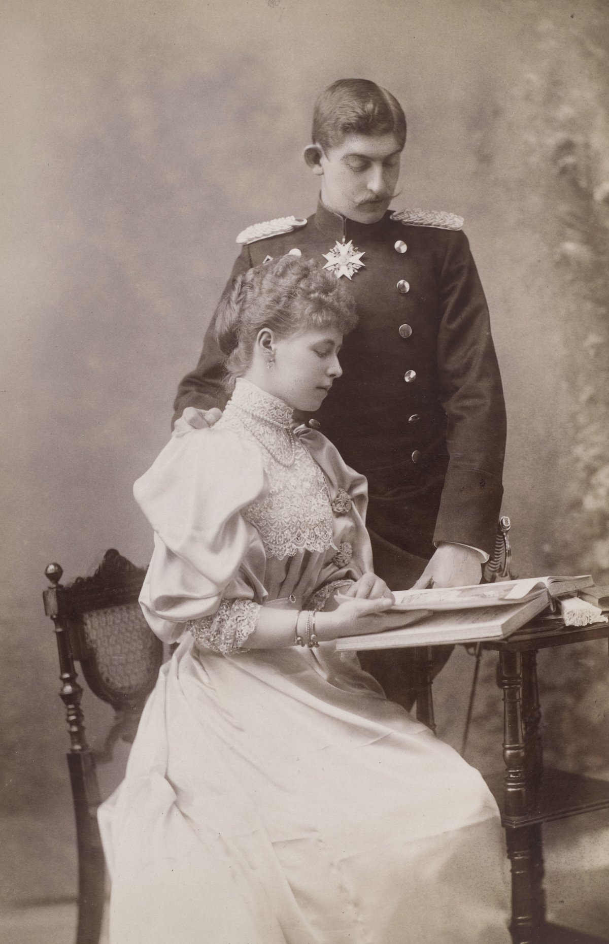 Princess Marie and Prince Ferdinand pose with a book in a photograph taken by Eduard Uhlenhuth in 1893 (Royal Collection Trust)