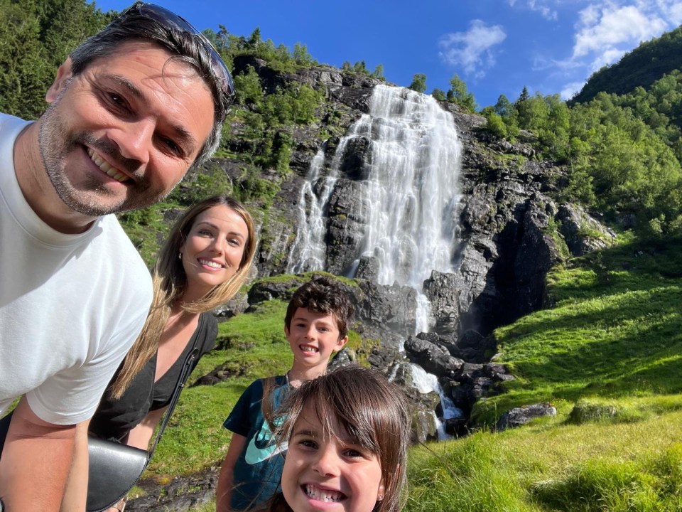Family selfie in front of a waterfall.