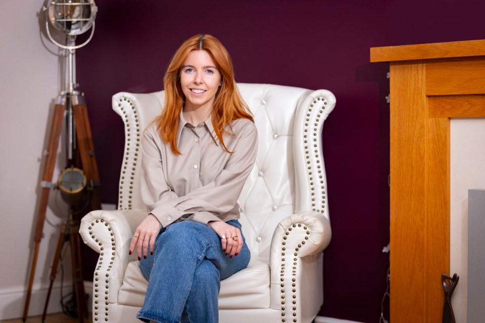 Stacey Dooley sitting in a white armchair.