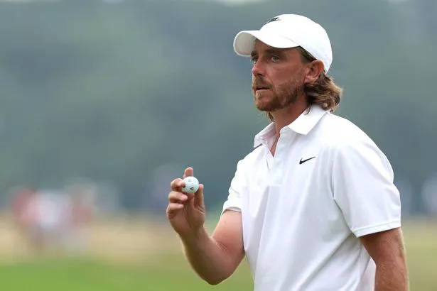 Tommy Fleetwood looks on while holding his golf ball