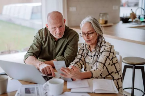 An elderly couple looking at paperwork together