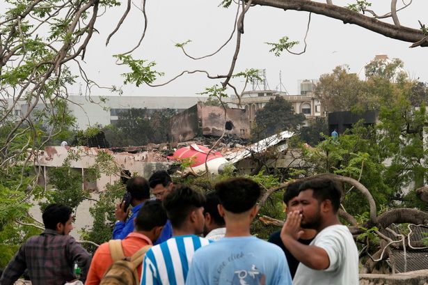 People look at parts of an Air India plane that crashed on Thursday