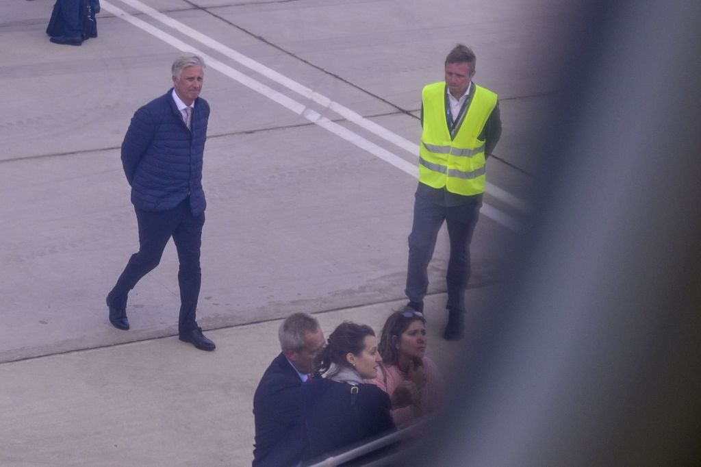 King Philippe looks at an aeroplane on airport tarmac