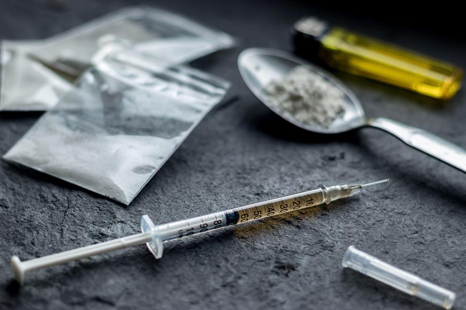 Syringe, spoon with heroin, and baggies of drugs.