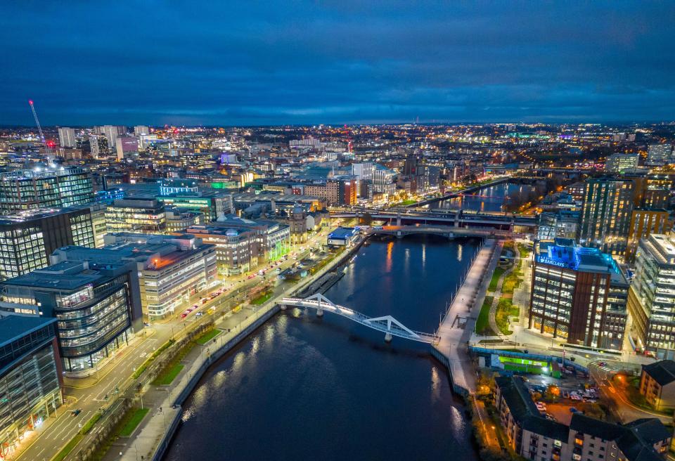 Aerial view of Glasgow at night, showing the River Clyde and city skyline.