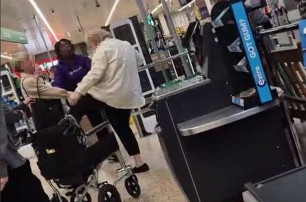 The woman appears to kick another shopper who falls to the ground