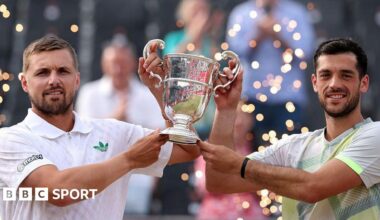 Lloyd Glasspool and Julian Cash hold the men's doubles trophy at Queen's