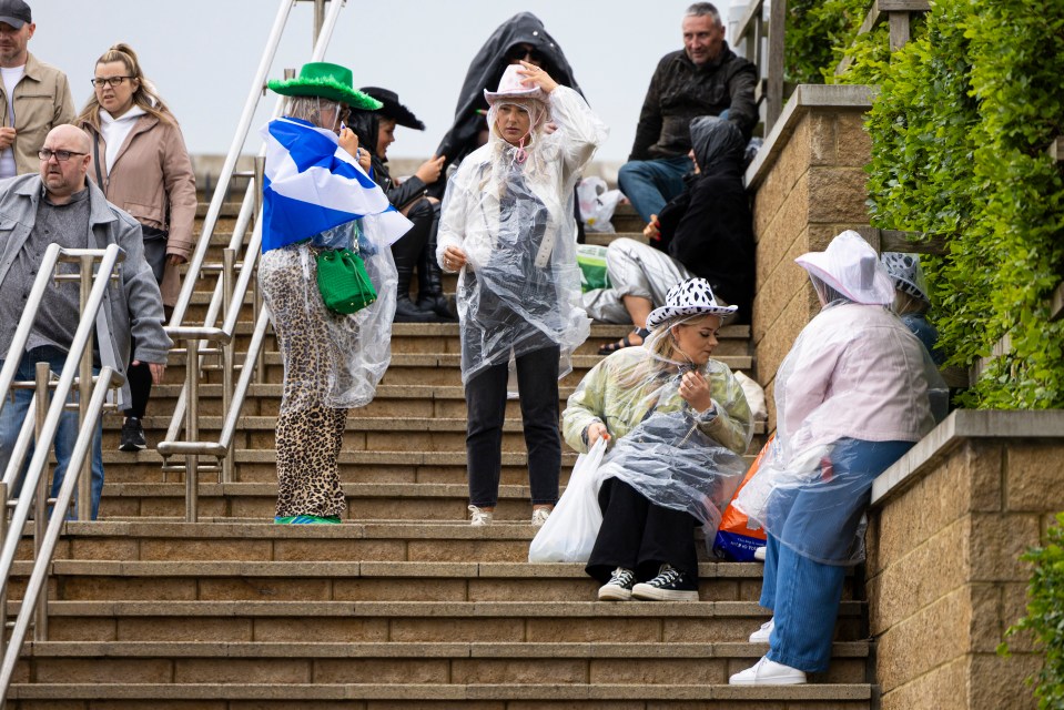 Fans in ponchos and hats at Murrayfield Stadium.