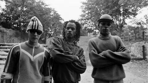 Beezer Three members of Wild Bunch, a groups of Djs and vocalists from St Paul's Bristol. The picture was taken in the 1980s in Montpelier, Bristol. 