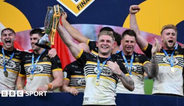Liam Harris lifting the 1895 Cup alongside team-mates