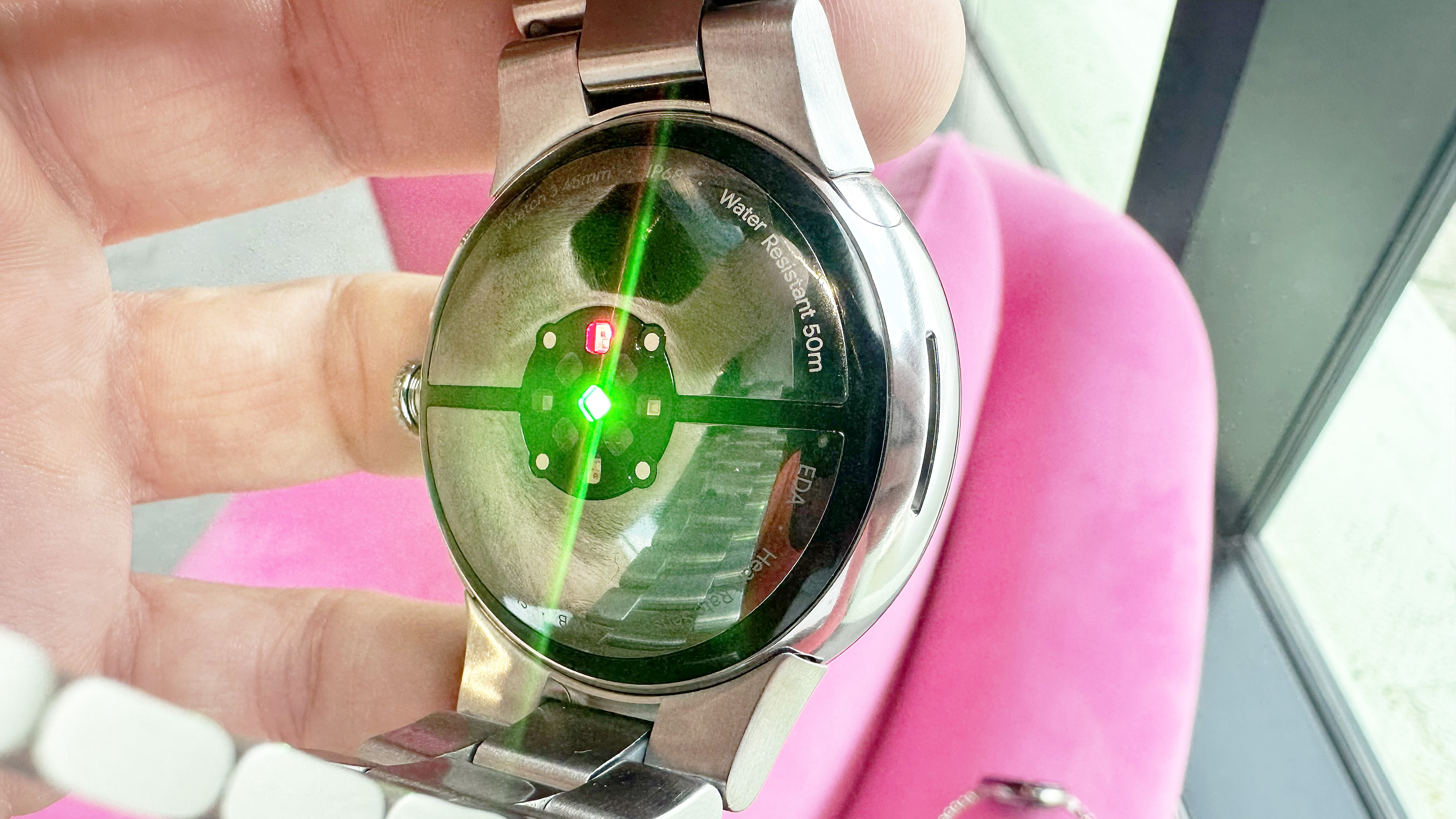 The back of the Pixel Watch 3 with a sensor light shining in green