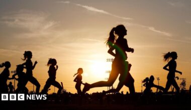 A group of people running at sunset.