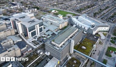 An aerial view of Aberdeen Royal Infirmary with surrounding buildings and ambulances queued outside
