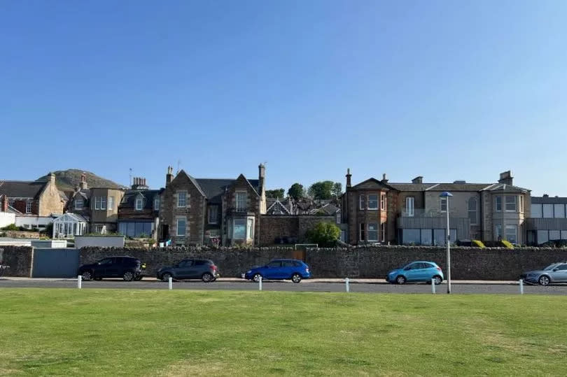 Single storey bank hall seen from beach front in North Berwick sandwiched between residential properties
