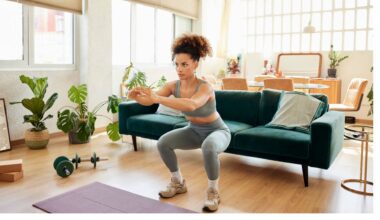 woman does bodyweight squat in her living room