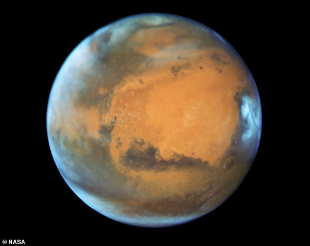 Mars is the fourth planet from the sun - a dusty, cold, desert world with a thin atmosphere. Pictured, Mars captured by the Hubble telescope