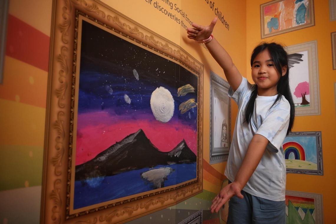 Chua Kah Ing, 10 with her artwork exhibited at the SELebrate! ? The Colours of Emotion: A Journey in Art exhibition in Bedok library on June 20, 2025.