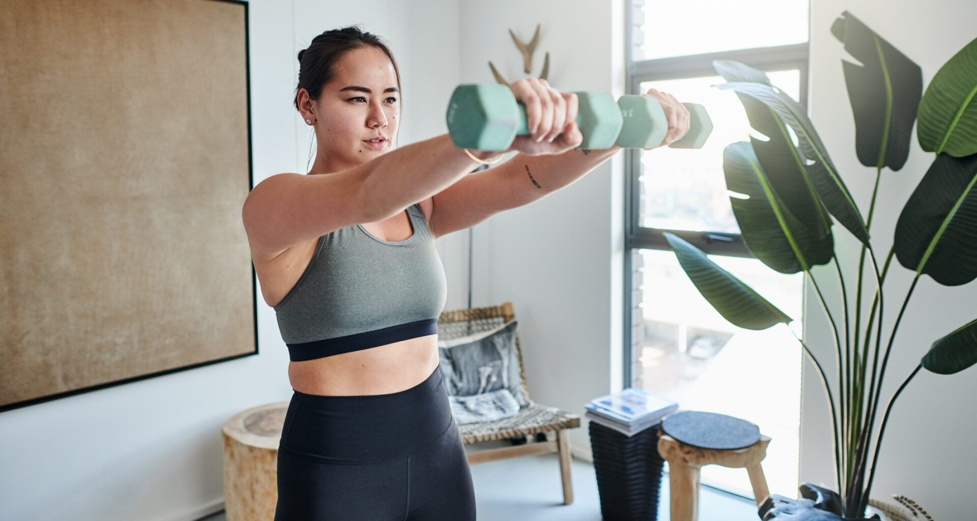 Woman exercising with dumbbells at home