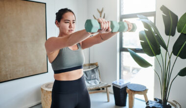 Woman exercising with dumbbells at home