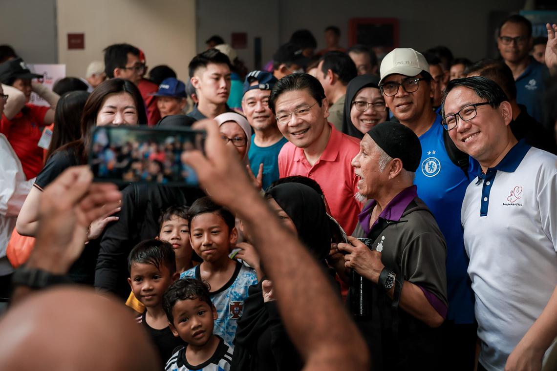 Prime Minister Lawrence Wong interacting with participants after their walk during the Hijrah Walk & Health Fiesta held at Choa Chu Kang Stadium on June 28, 2025. With him are Advisers to Marsiling-Yew Tee GRC GROs, Senior Minister of State Zaqy Mohamad, Mayor Alex Yam and Ms Hany Soh.