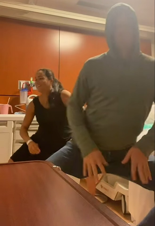 Photo of a couple in a hospital room, the woman appears to be in labor.