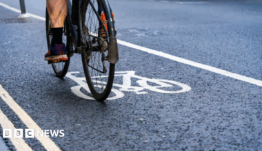 Someone riding a black bike in a cycle lane.