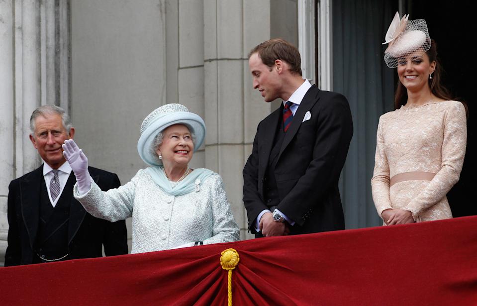 Queen Elizabeth waving from the balcony at Buckingham Palace with Prince Charles, Prince William and Kate Middleton in 2012
