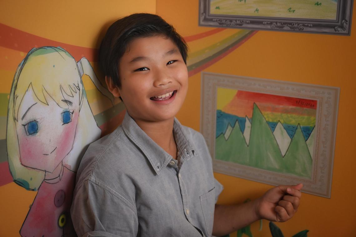 Samuel Lee, 11 with his artwork exhibited at the SELebrate! ? The Colours of Emotion: A Journey in Art exhibition in Bedok library on June 20, 2025.