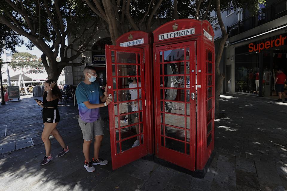 GIBRALTAR, UNITED KINGDOM - SEPTEMBER 06: People use the red phone booths in Gibraltar, a tiny British overseas territory located on the southern tip of the Iberian Peninsula, on September 06, 2021 in Gibraltar, United Kingdom. It is home to around 32,000 people and has the 5th highest density of any country or territory in the world. It has no land borders with any country besides Spain. In January Spain and the United Kingdom reached a last-minute preliminary deal on the status of post-Brexit Gibraltar. In the 2016 Brexit referendum, 96% of voters in Gibraltar opted to remain in the EU. Gibraltar is on the UNâs list of ânon-self-governing territoriesâ.The United Nations defines non-self-governing territories as those 