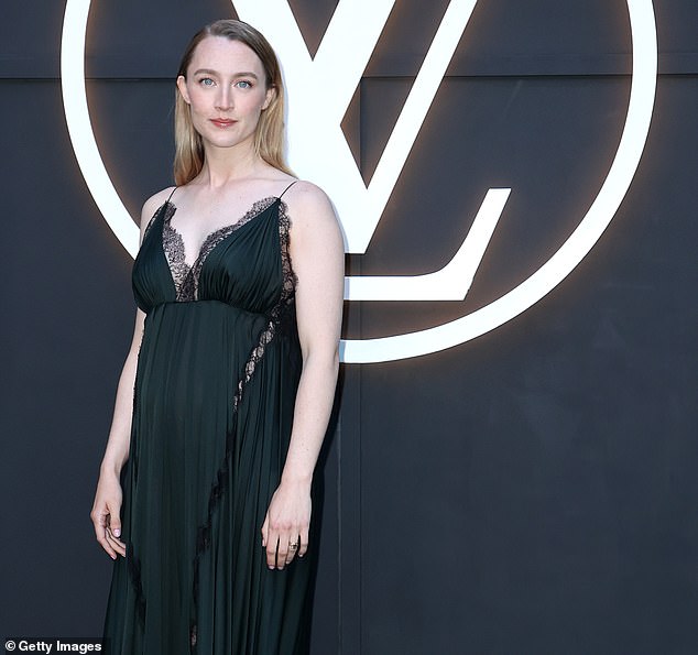 Ronan wore a black pleated low-neck dress with dark green hue featuring delicate lace trim and thin straps