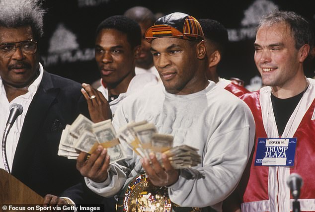 Standing alongside promoter Don King, Tyson flashes some cash to the media