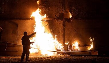A firefighter stands by a fire and points to a hole following a drone strike in Kharkiv on June 5