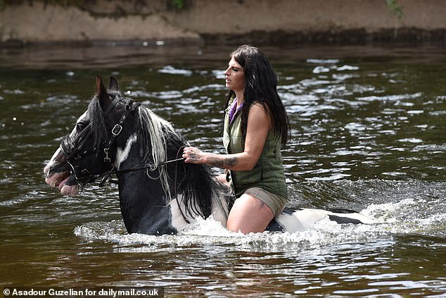A young woman takes a horse for a swim in the River Eden