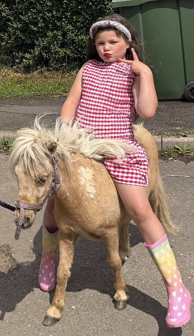 A young girl rides a pony at the fair