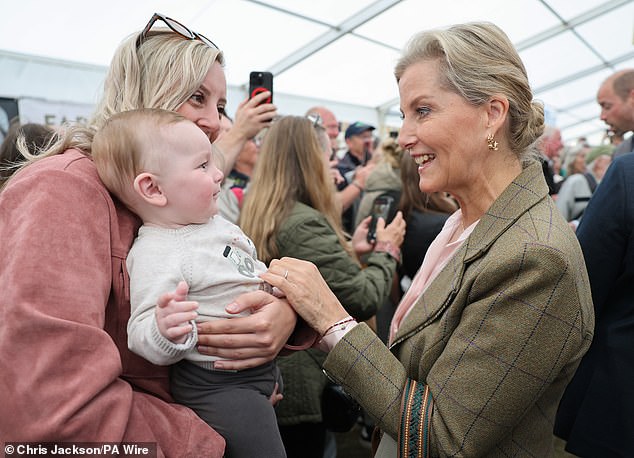 The Duchess of Edinburgh speaking with a mother and her baby during her visit to the Food and Farming Pavilion at the Royal Cornwall Show
