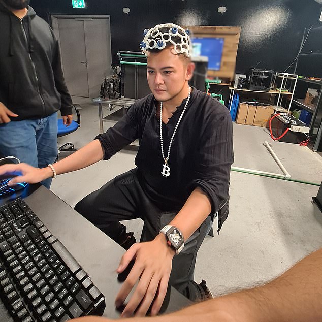Herbert Sim (pictured) works with his company's transhuman helmet, turning his brainwaves into readable actions for a computer