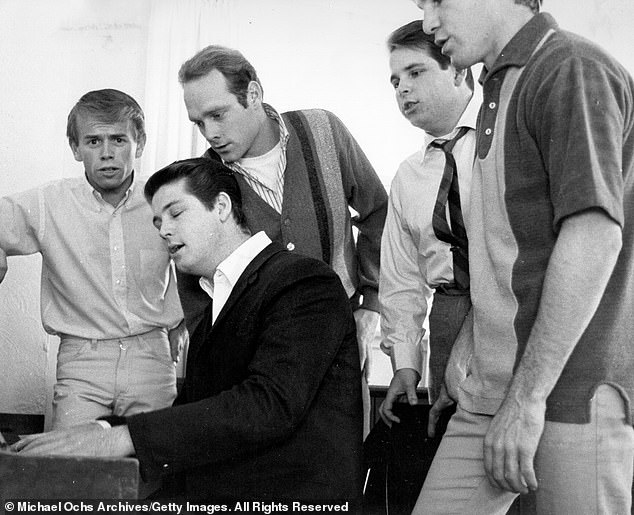 Wilson (second from left) is pictured with the other Beach Boys in 1964