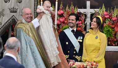 The chief priest, Bishop Johan Dalman, holds up Princess Ines after he baptizes her. Prince Carl Philip and Princess Sofia are pictured on the right