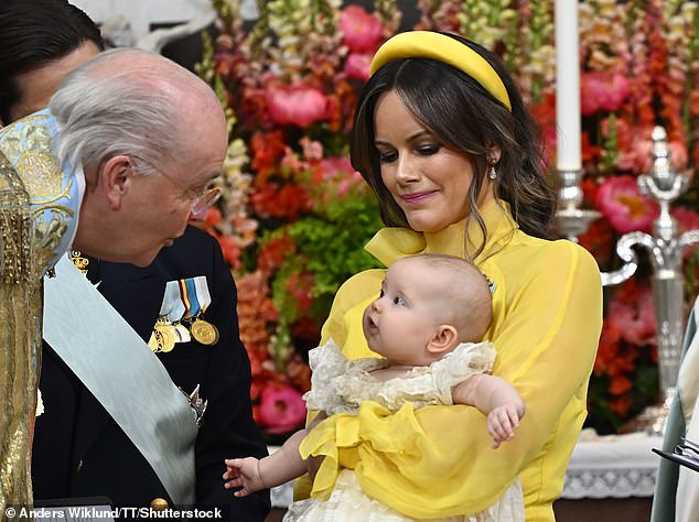 Sofia looked the picture of elegance in her yellow ensemble as she held her daughter during the ceremony