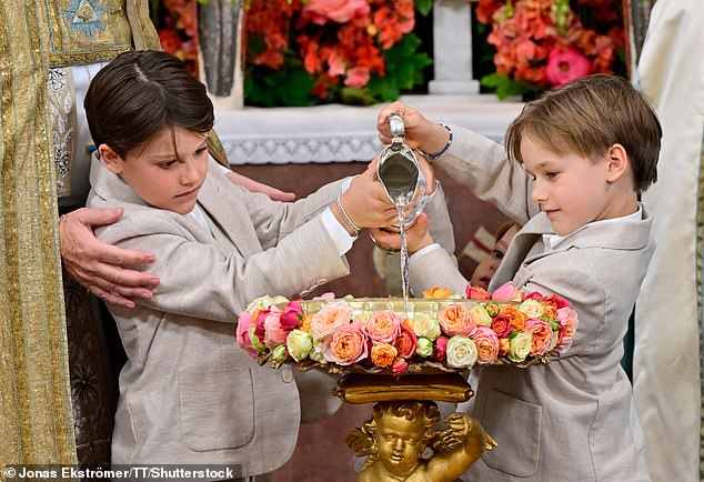 Prince Alexander and Prince Gabriel fill the baptismal font during Princess Ines' christening