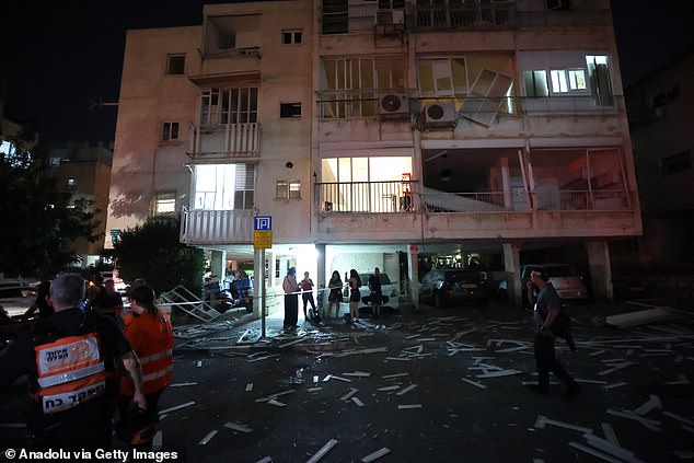 Israeli army, dispatched to the area, evacuate residents from damaged buildings following Iran's retaliatory missile strikes against Israel