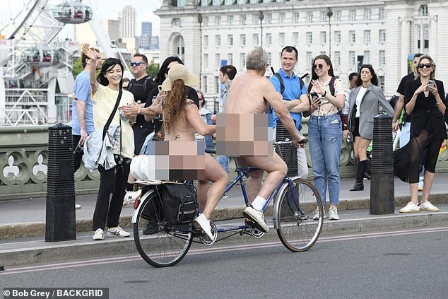 Cheek to cheek: naked riders on a tandem bike gave excited onlookers a high five