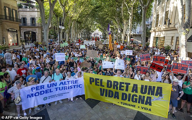 Demonstrators in Mallorca holds banners reading 'For another tourism model' and 'For the right to a decent life' on June 15