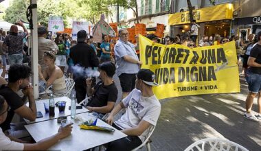 Tourists watch in Mallorca as demonstrators hold a banner reading 'For the right to a decent life' on June 15, 2025