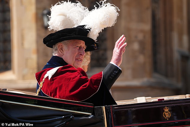 The King, resplendent in the traditional velvet robes and plumed hat of the Order of the Garter, leaving the ceremony