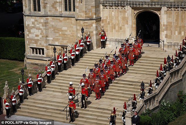 Yeomen Warders and members of the household cavalry wait outside the chapel during the Order of the Garter service at St George's Chapel in Windsor Castle