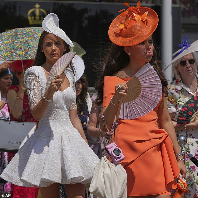 Racegoers use fans to keep themselves cool as temperatures are set to rise to 30C at Ascot